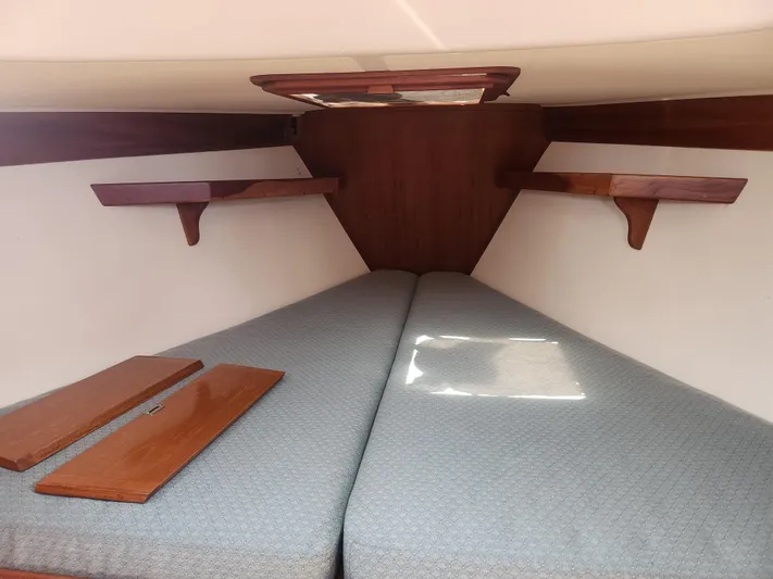 Sensation Yacht Photos Pics Interior cabin of 1998 Tartan 4100 sailboat with wooden shelves and cushioned berth.
