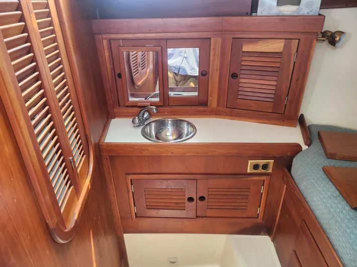 Sensation Yacht Photos Pics Wooden interior of 1998 Tartan 4100 sailboat with sink and storage cabinets.