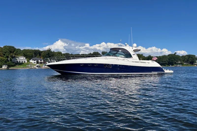 Apres Sea Yacht Photos Pics 2006 Sea Ray 52 Sundancer yacht on calm water, clear blue sky background.