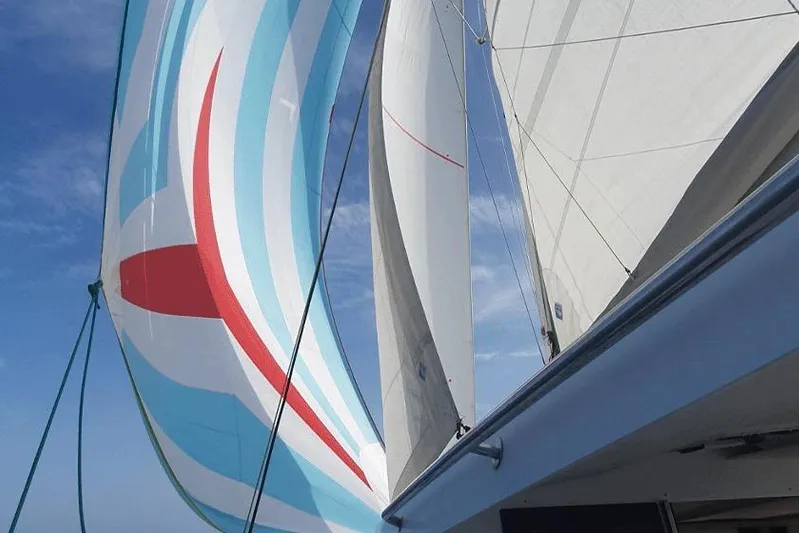  Yacht Photos Pics Sailing on a 2018 Fountaine Pajot Lucia 40 with colorful spinnaker against blue sky.