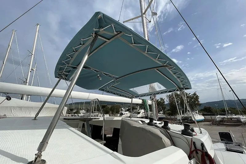  Yacht Photos Pics 2018 Fountaine Pajot Lucia 40 catamaran with blue canopy, docked in marina.