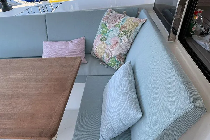 Yacht Photos Pics Cozy seating area on 2018 Fountaine Pajot Lucia 40 yacht with cushions and wooden table.