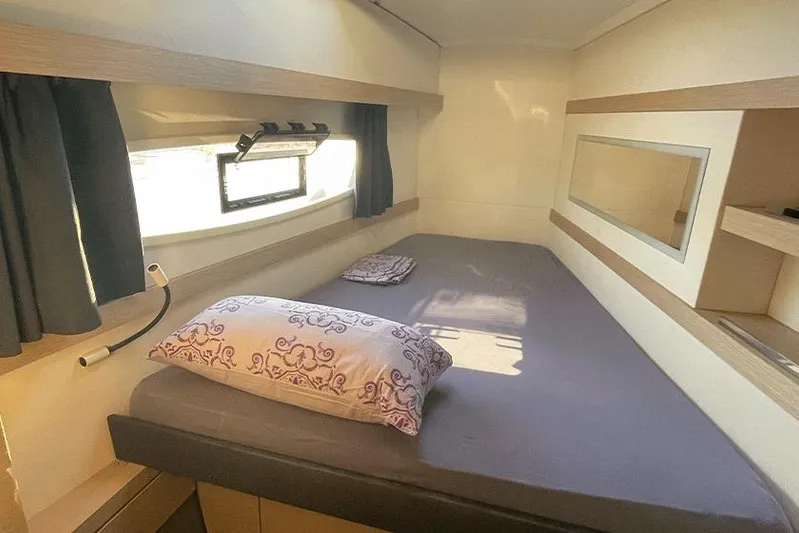  Yacht Photos Pics Cozy cabin interior of 2018 Fountaine Pajot Lucia 40 catamaran with bed and window.