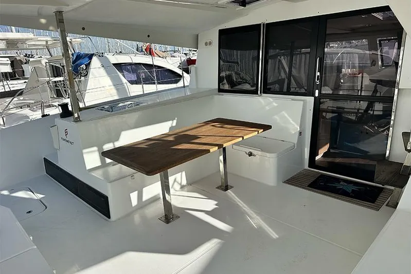 Yacht Photos Pics 2018 Fountaine Pajot Lucia 40 catamaran cockpit with wooden table and seating area.