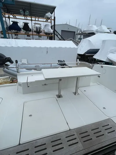  Yacht Photos Pics 2018 Fountaine Pajot MY 37 yacht deck with seating and table, docked in a marina.