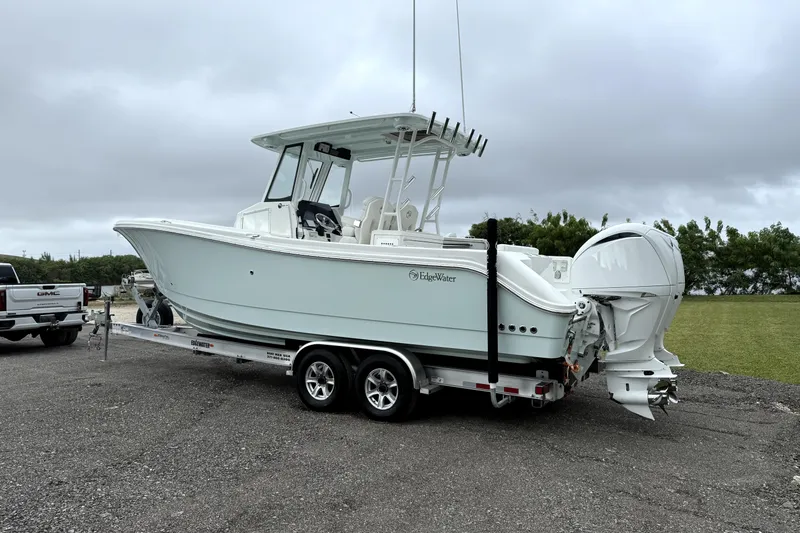  Yacht Photos Pics 2023 Edgewater 285CC boat on trailer, parked outdoors under cloudy sky.