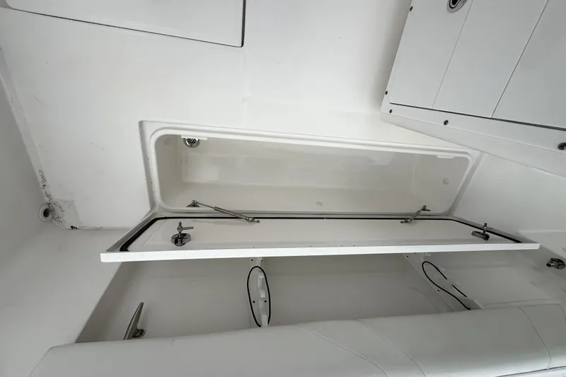  Yacht Photos Pics 2023 Edgewater 285CC boat storage compartment with open hatch, showcasing interior design.