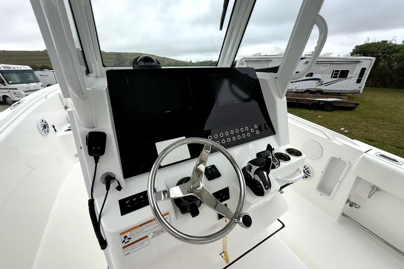  Yacht Photos Pics 2023 Edgewater 285CC boat dashboard with steering wheel and control panel.