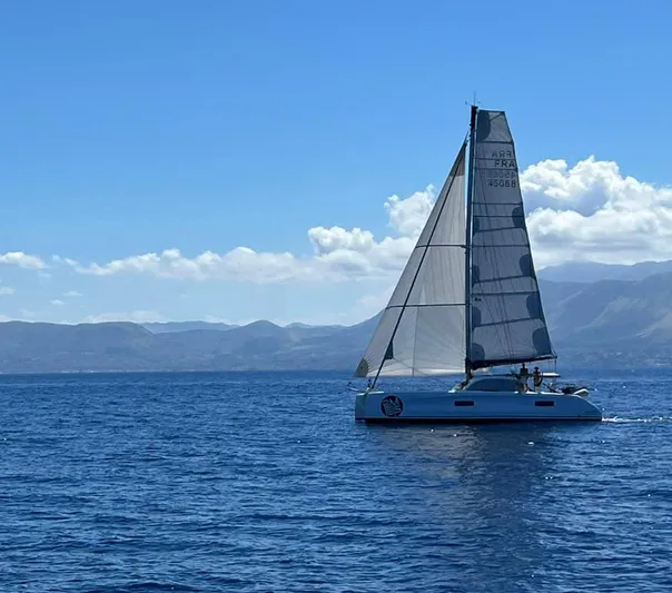 Peems Yacht Photos Pics Outremer 45 catamaran sailing on open sea, 2022 model, under clear blue sky.