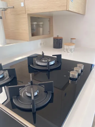 Peems Yacht Photos Pics Modern kitchen with sleek black gas stove on Outremer 45 yacht, 2022 model.