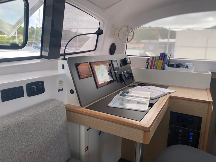 Peems Yacht Photos Pics Navigation station inside 2022 Outremer 45 yacht with charts and electronic displays.