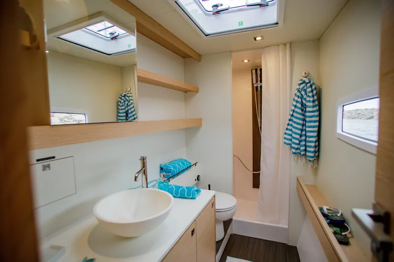 Peems Yacht Photos Pics Modern bathroom in 2022 Outremer 45 yacht with skylights and striped towels.