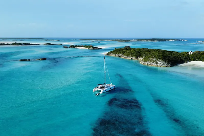 Peems Yacht Photos Pics Outremer 45 catamaran sailing in turquoise waters near lush islands, 2022 model.
