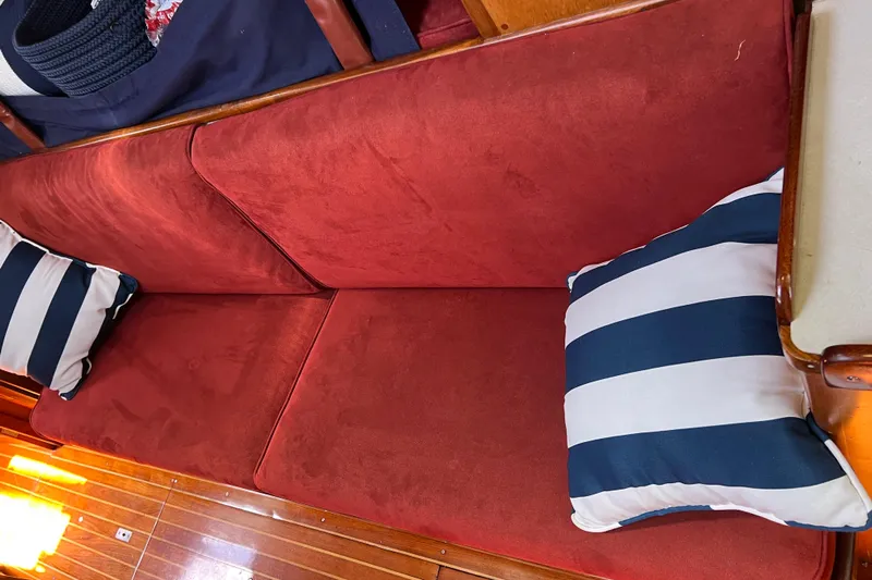 Courage Yacht Photos Pics Red cushioned seating with striped pillows on a 1980 Hinckley 43 boat interior.