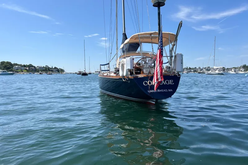 Courage Yacht Photos Pics 1980 Hinckley 43 sailboat on calm water, displaying an American flag.