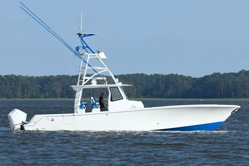  Yacht Photos Pics 2024 SeaVee 420Z boat cruising on water with forested shoreline in background.