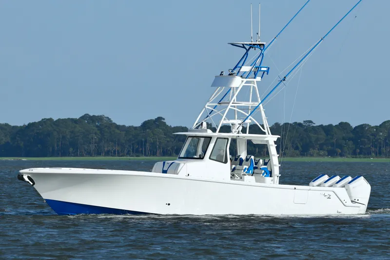  Yacht Photos Pics 2024 SeaVee 420Z boat cruising on water with forested shoreline in background.