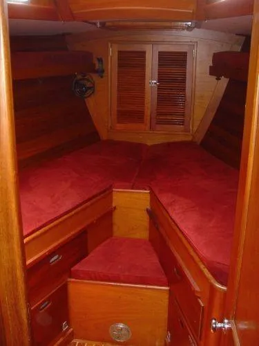 Courage Yacht Photos Pics 1980 Hinckley 43 yacht cabin with red cushions and wooden interior.