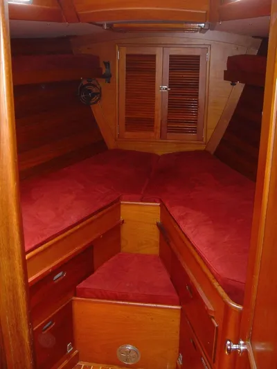 Courage Yacht Photos Pics Cozy cabin interior of 1980 Hinckley 43 with red cushions and wooden finish.