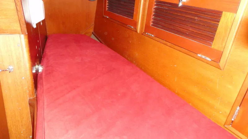 Courage Yacht Photos Pics 1980 Hinckley 43 interior with red cushioned seating and wooden paneling.