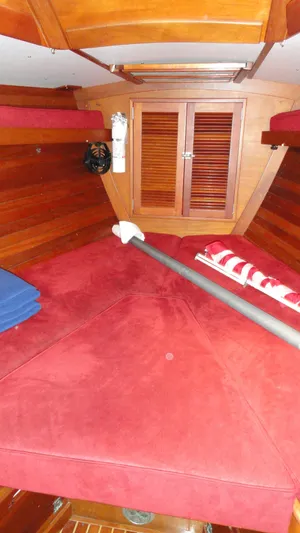 Courage Yacht Photos Pics Interior of 1980 Hinckley 43 sailboat with red cushions and wooden paneling.