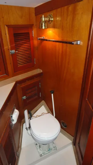 Courage Yacht Photos Pics 1980 Hinckley 43 yacht bathroom with wooden cabinetry and marine toilet.