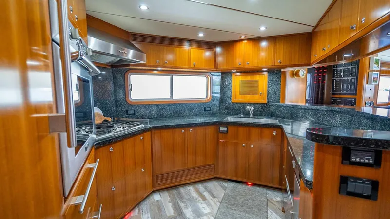 Take 5 Yacht Photos Pics Luxurious kitchen interior of 2009 Nordhavn 76 yacht with wood cabinetry and modern appliances.