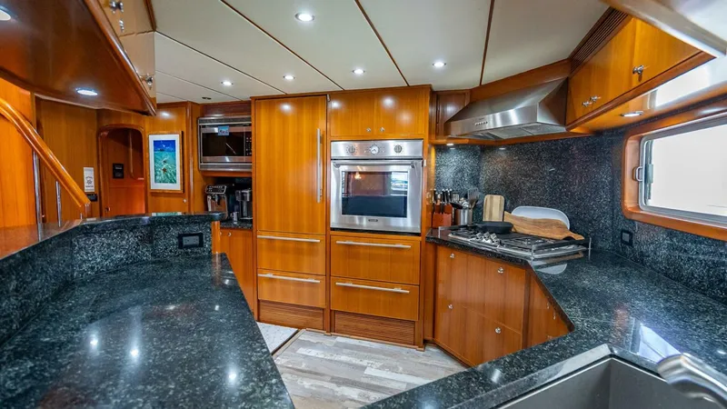 Take 5 Yacht Photos Pics Luxurious kitchen interior of 2009 Nordhavn 76 yacht with wood cabinetry and granite countertops.