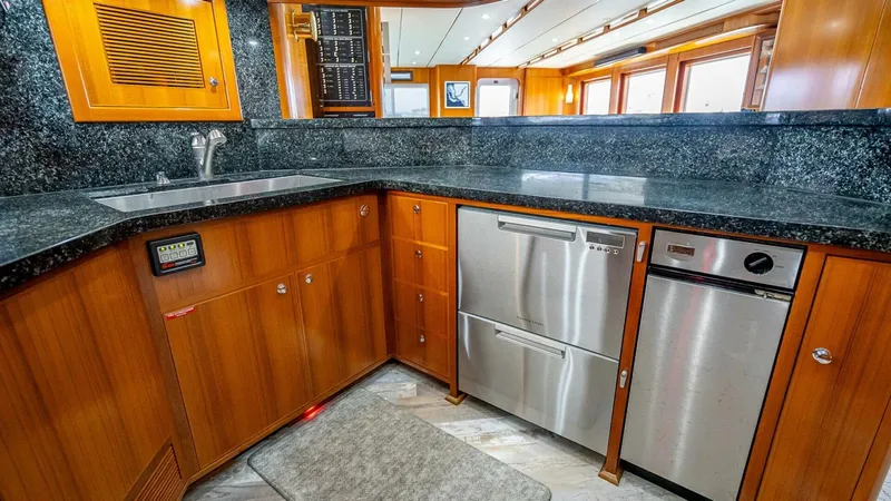 Take 5 Yacht Photos Pics Luxurious kitchen in 2009 Nordhavn 76 yacht with wood cabinetry and stainless steel appliances.