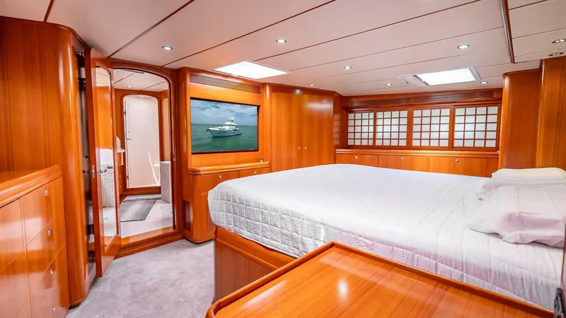 Take 5 Yacht Photos Pics Luxurious cabin interior of 2009 Nordhavn 76 yacht with wood paneling and large bed.