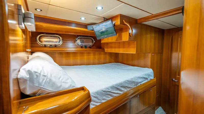 Take 5 Yacht Photos Pics Luxurious cabin interior of 2009 Nordhavn 76 yacht with wood paneling and cozy bed.