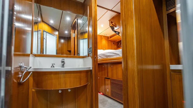 Take 5 Yacht Photos Pics Luxurious wooden interior of 2009 Nordhavn 76 yacht cabin with sink and bed.