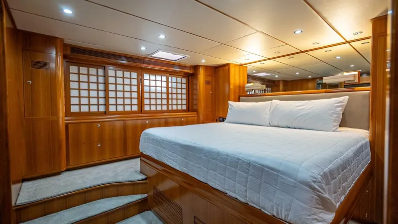 Take 5 Yacht Photos Pics Luxurious cabin interior of 2009 Nordhavn 76 yacht with wooden finishes and cozy bed.