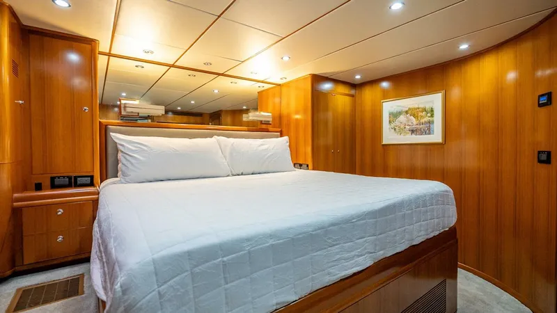 Take 5 Yacht Photos Pics Luxurious cabin interior of 2009 Nordhavn 76 yacht with wood paneling and cozy bed.