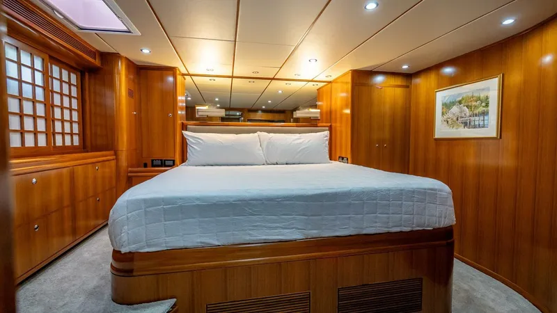 Take 5 Yacht Photos Pics Luxurious cabin interior of 2009 Nordhavn 76 yacht with wood paneling and cozy bed.