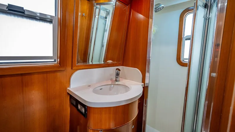 Take 5 Yacht Photos Pics Bathroom interior of 2009 Nordhavn 76 yacht with wooden cabinetry and modern fixtures.