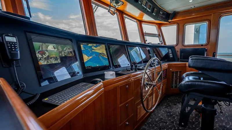 Take 5 Yacht Photos Pics Pilothouse of 2009 Nordhavn 76 yacht with navigation screens and steering wheel.