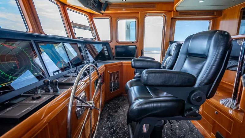 Take 5 Yacht Photos Pics Pilothouse of 2009 Nordhavn 76 yacht with leather chairs and advanced navigation equipment.