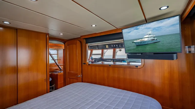 Take 5 Yacht Photos Pics Luxurious cabin interior of 2009 Nordhavn 76 yacht with wood paneling and mounted TV.