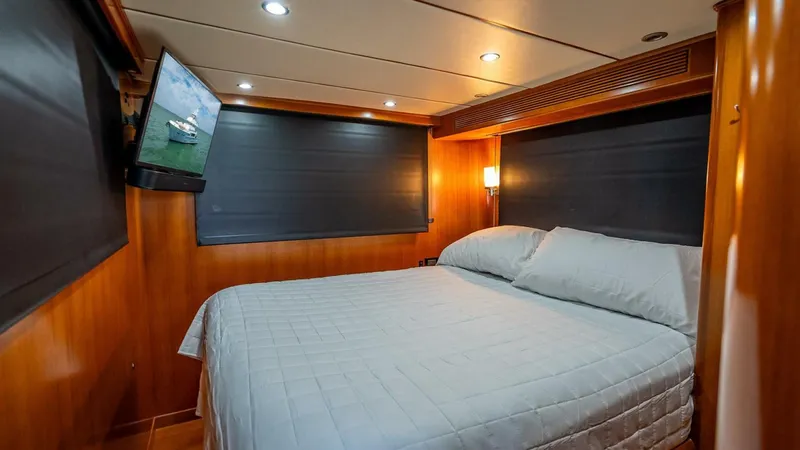 Take 5 Yacht Photos Pics Luxurious cabin interior of 2009 Nordhavn 76 yacht with cozy bed and TV.