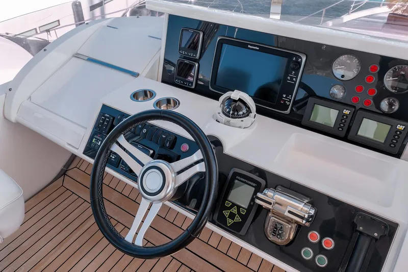  Yacht Photos Pics Control panel of a 2014 Princess 72 Motor Yacht with steering wheel and navigation instruments.
