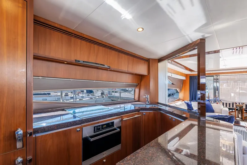  Yacht Photos Pics Luxurious kitchen interior of 2014 Princess 72 Motor Yacht with wood cabinetry and modern appliances.