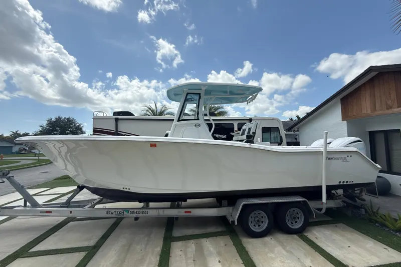  Yacht Photos Pics 2022 Tidewater 280 CC Adventure boat on trailer under a clear blue sky.