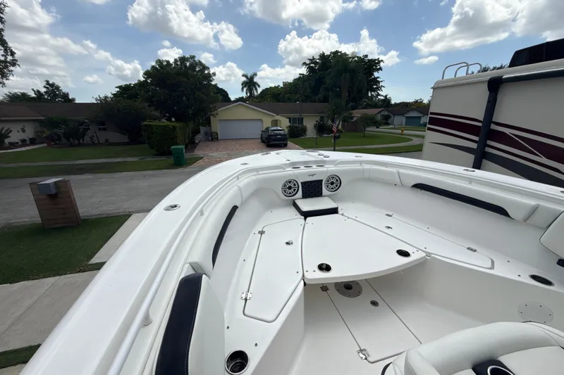  Yacht Photos Pics 2022 Tidewater 280 CC Adventure boat parked in a residential driveway under a cloudy sky.