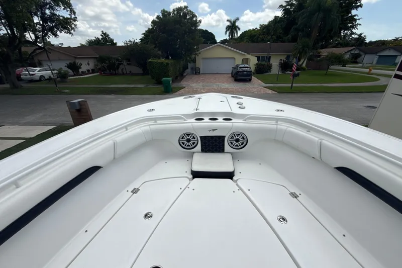  Yacht Photos Pics 2022 Tidewater 280 CC Adventure boat, spacious deck view, residential neighborhood background.