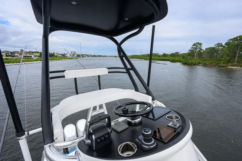 Patriot Yacht Photos Pics 2023 Valhalla Boatworks helm with steering wheel and controls, overlooking serene waterway.