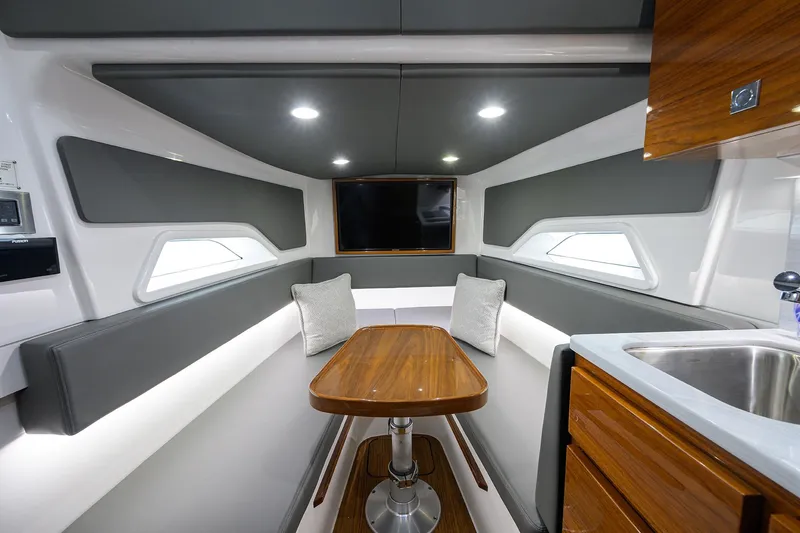 Patriot Yacht Photos Pics Luxurious 2023 Valhalla Boatworks cabin interior with modern seating, table, and kitchenette.