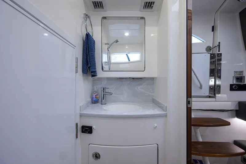 Patriot Yacht Photos Pics Modern 2023 Valhalla Boatworks bathroom with sleek sink, mirror, and wooden steps.