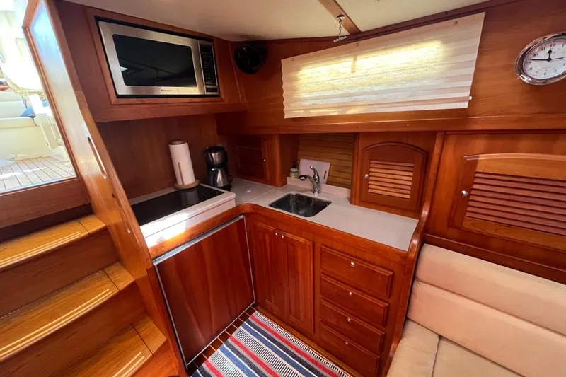 Shibumi Yacht Photos Pics 2004 Sabre 42 Hardtop Express yacht kitchen with wood cabinetry, microwave, and sink.