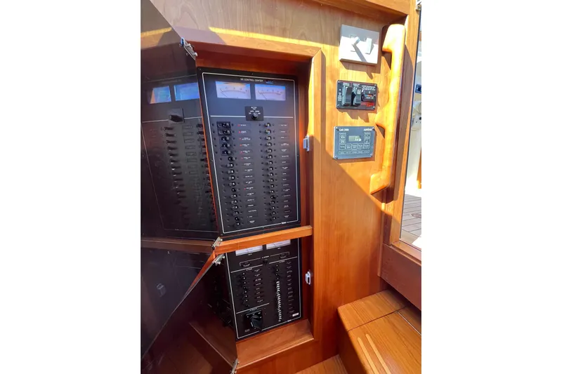 Shibumi Yacht Photos Pics Electrical control panel inside 2004 Sabre 42 Hardtop Express yacht, featuring wooden cabinetry.